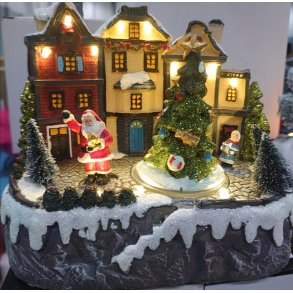 JULESCENE MED JULEMAND STENDE VED JULETR OG FORAN HUSE 